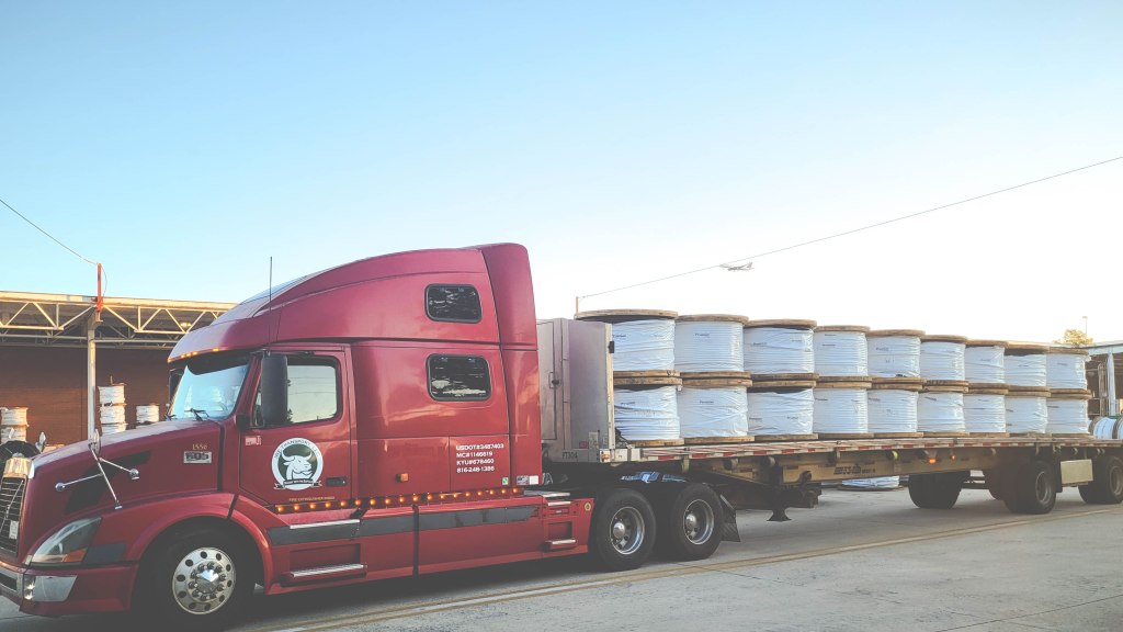 Image: IRF Transport flatbed shipping truck preparing to haul construction supplies.